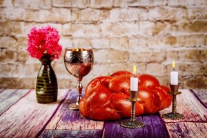 Shabbat candles in candlesticks of loaves challah for Shabbat with wine in a kiddush cup