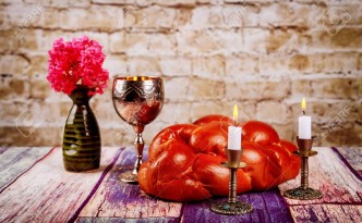 Shabbat candles in candlesticks of loaves challah for Shabbat with wine in a kiddush cup