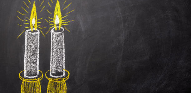 Two candles painted on a chalkboard with copy space.